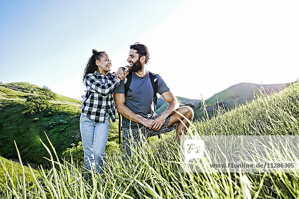 Vater und Tochter lächelnd auf einem Hügel