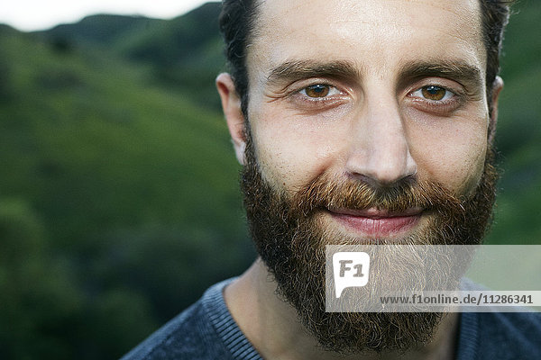 Close up of smiling Mixed Race man with beard