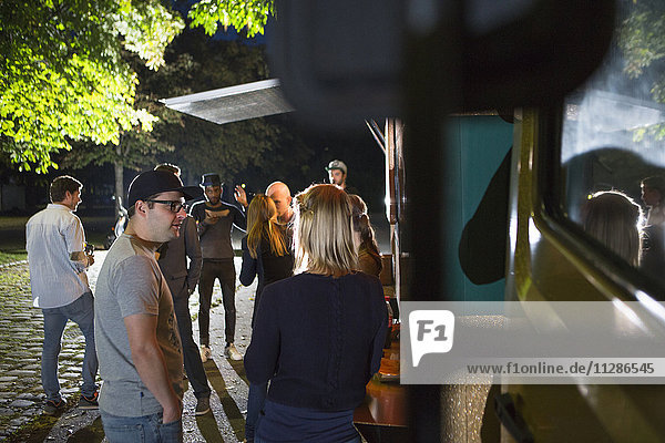 Group of customers at food truck at night