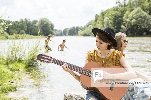 Group of friends relaxing on the riverbank