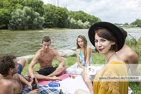 Eine Gruppe von Freunden entspannt sich am Flussufer