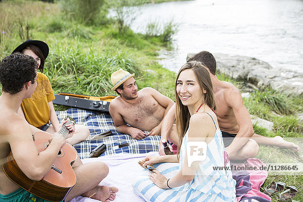 Group of friends relaxing on the riverbank