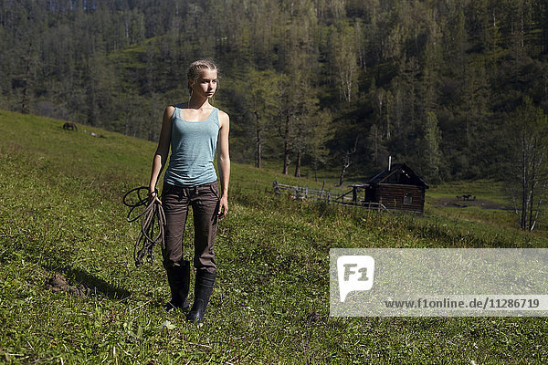 Kaukasisches Mädchen hält Seil auf einem Hügel