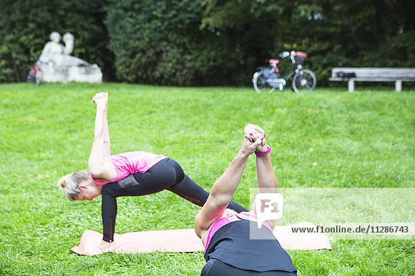 Junge Frauen üben Yoga im Park