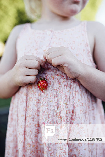 Mädchen hält Erdbeere