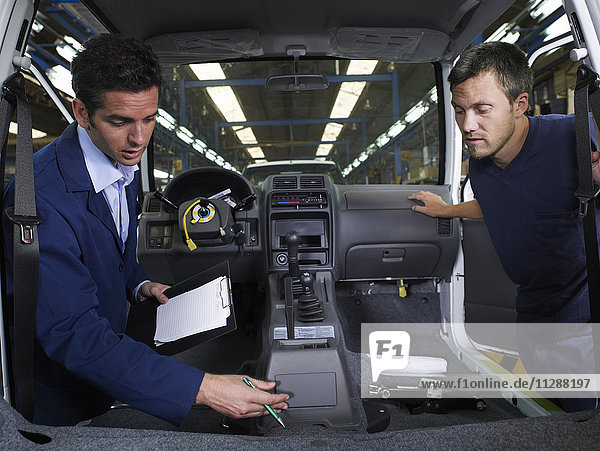 Two Men Inspecting Car