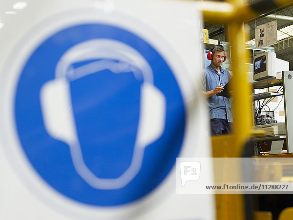 Mann trägt Gehörschutz in einem Automobilwerk