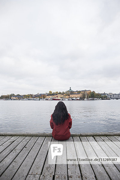 Schweden  Stockholm  Rückansicht der Frau am Pier mit Blick auf die Stadt