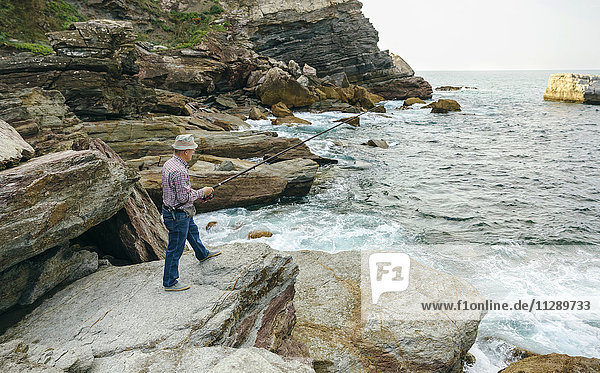 Senior Mann beim Fischen am Meer