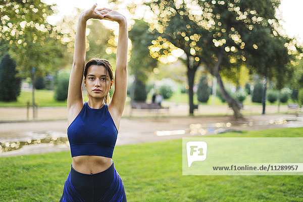 Sportliche junge Frau beim Stretching im Park