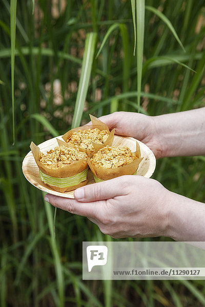 Person holding plate with oat muffins