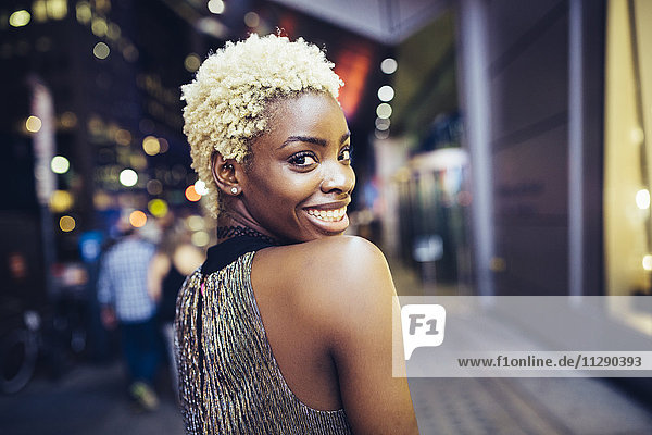 USA  New York City  lächelnde junge Frau am Times Square bei Nacht