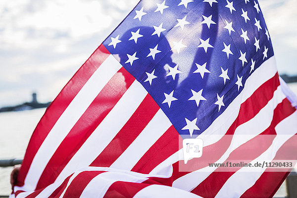 Silhouette der Frau hinter der amerikanischen Flagge