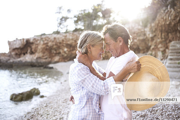 Fröhliches Seniorenpaar von Angesicht zu Angesicht am Strand