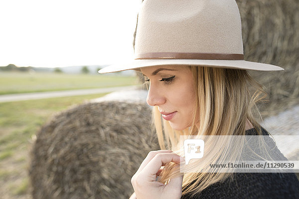 Junge Frau mit Hut in ländlicher Landschaft