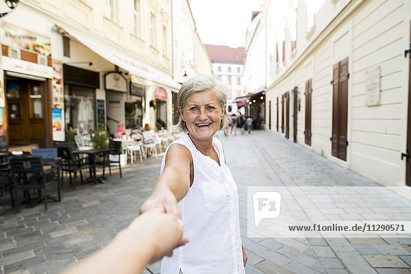 Slowakei  Bratislava  Porträt einer glücklichen Seniorin mit Männerhand auf der Straße