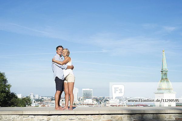 Slowakei  Bratislava  glückliches Paar  das auf einer Mauer steht und sich umarmt