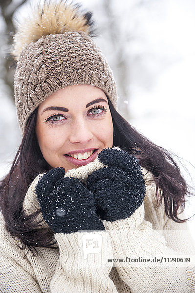 Porträt einer lächelnden Frau in Strickwaren im Winter