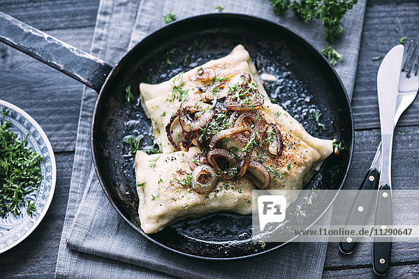 Vegetarische Schwäbische Taschen mit gerösteten Zwiebeln in der Pfanne