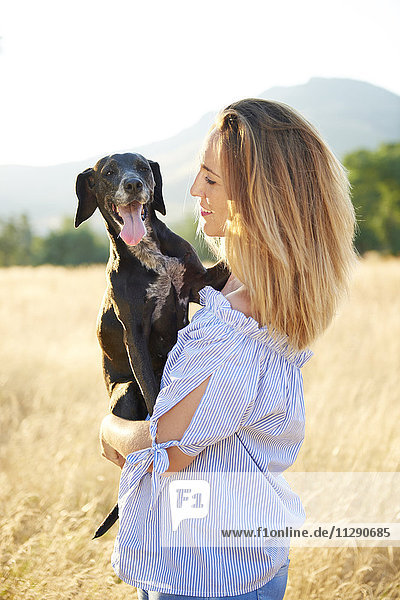 Glückliche Frau mit ihrem Hund in der Natur
