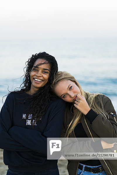Porträt von zwei glücklichen jungen Frauen am Strand