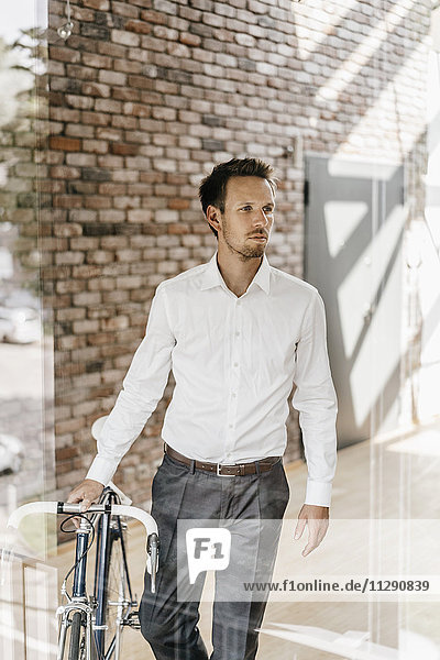 Geschäftsmann mit Fahrrad im Büro