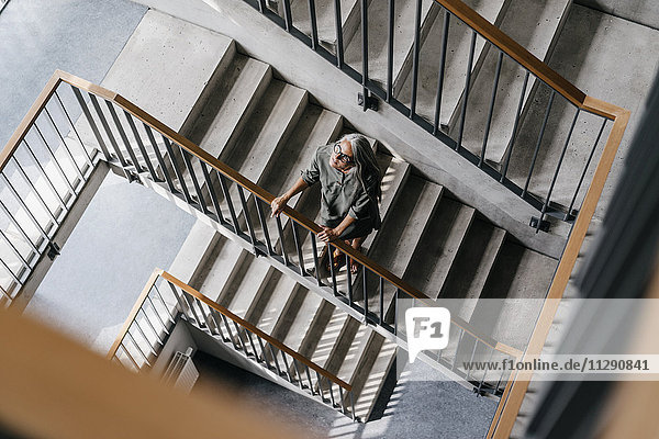 Woman with long grey hair in staircase