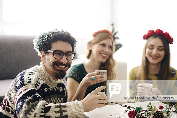Porträt eines lächelnden Mannes mit Freunden zur Weihnachtszeit