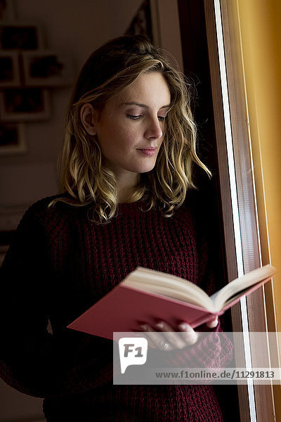 Frau beim Lesen eines Buches zu Hause