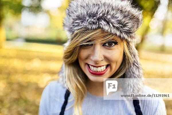 Porträt einer lächelnden jungen Frau mit Pelzmütze
