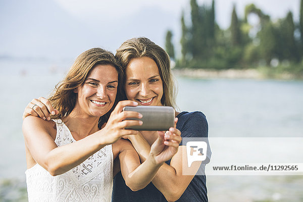 Italien  Gardasee  zwei junge Frauen mit einem Selfie