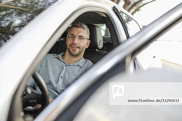 Mann im Auto sitzend eine Pause machend