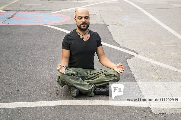 Porträt eines Mannes mit geschlossenen Augen  der auf der Straße meditiert.