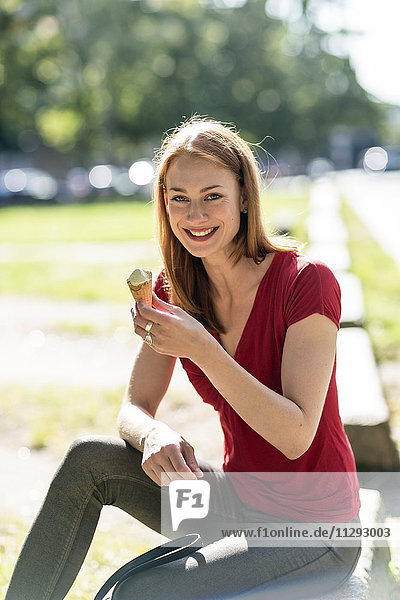 Porträt einer lächelnden Frau beim Eis essen