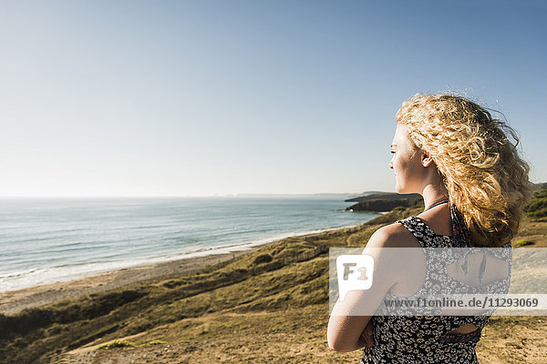 Blondes Teenagermädchen genießt Blick aufs Meer