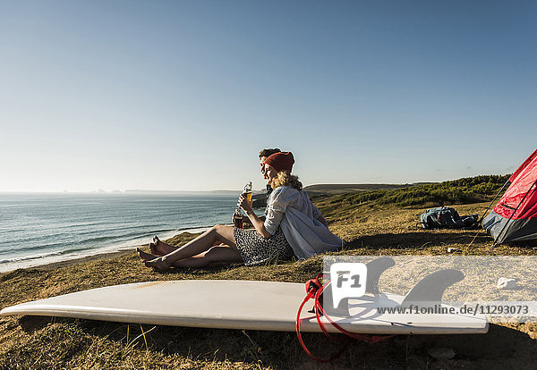 Junges Paar mit Surfbrett-Camping am Meer