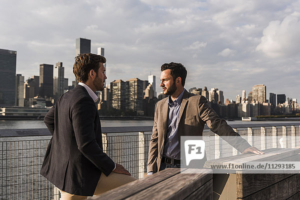 USA  New York City  zwei Geschäftsleute im Gespräch am East River