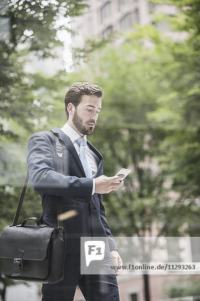 Businessman walking looking at cell phone