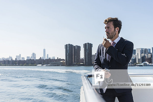 USA  New York City  businessman telephoning on ferry on East River