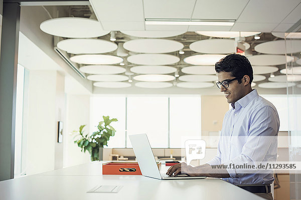 Businessman working at high desk using laptop