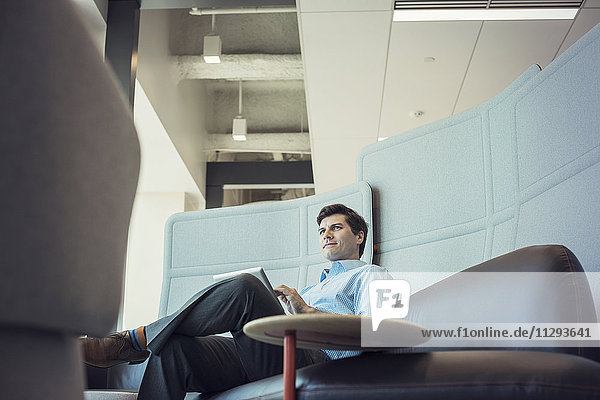 Businessman sitting in office  using digital tablet