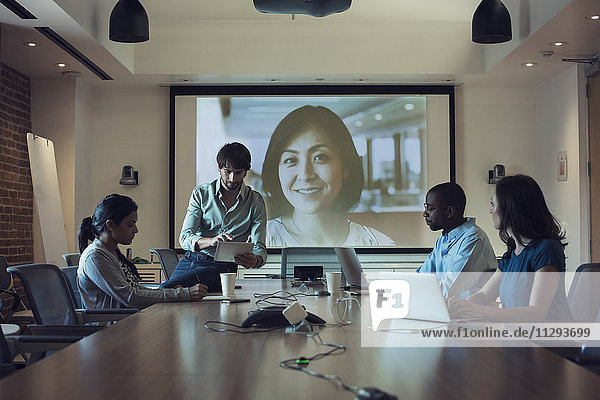 Geschäftsleute mit einer Videokonferenz im Sitzungssaal