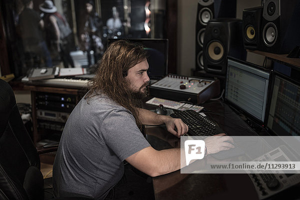 Audio engineer working on computer at recording studio