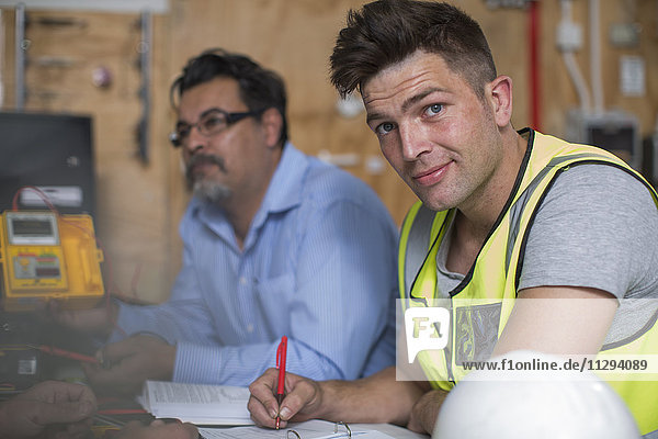 Confident young man attending an electrician workshop