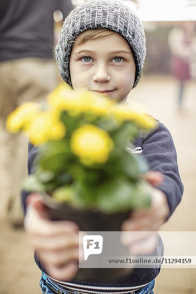 Junge mit gelbem Blumentopf
