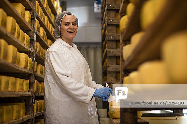 Käsereiarbeiter beim Auftragen von Wachs auf Käse