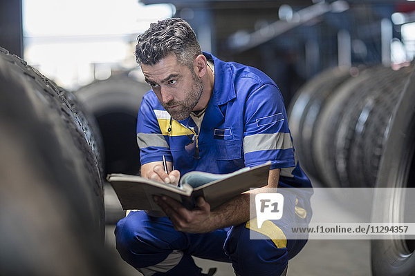 Man in tire repair factory taking notes