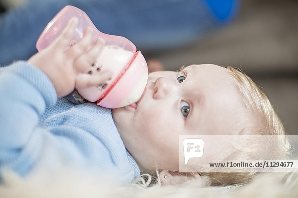 Baby girl drinking bottle of milk