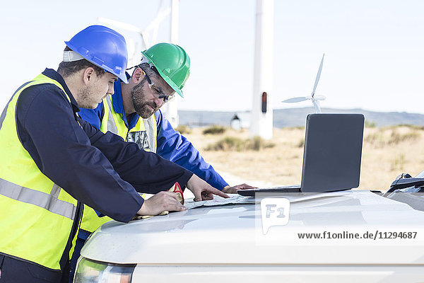 Ingenieure im Windpark mit Blick auf die Karte