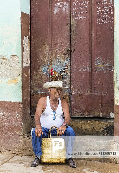 Alter kubanischer Mann mit einem Hahn auf dem Kopf  Trinidad  Provinz Sancti Spiritus  Kuba  Mittelamerika